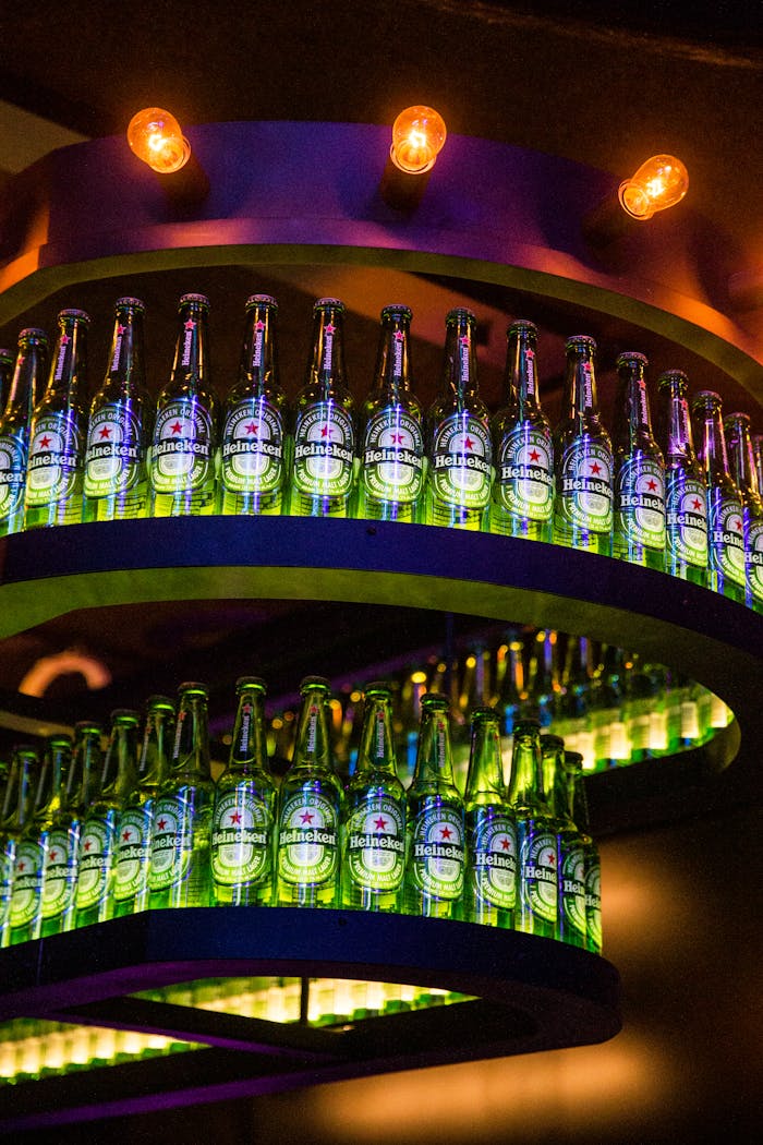 Multiple Heineken beer bottles on a vibrant LED-lit display in a nightclub setting.
